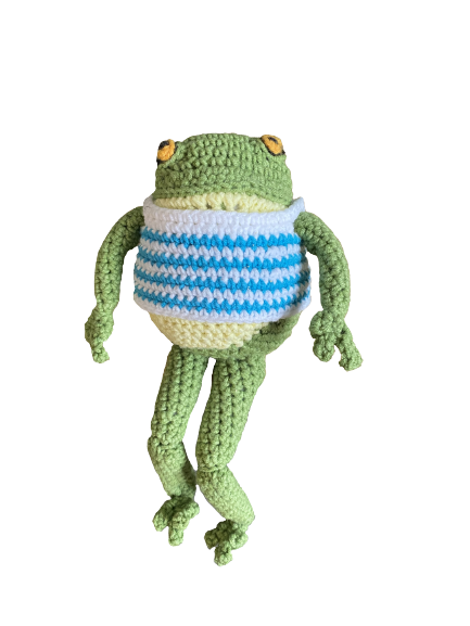 A crocheted frog, wearing a blue and white striped vest